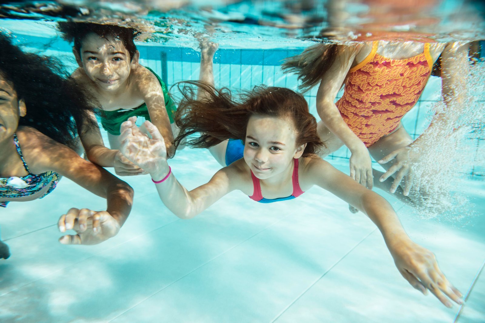 Vier kinder unterwasser schauen in die kammer